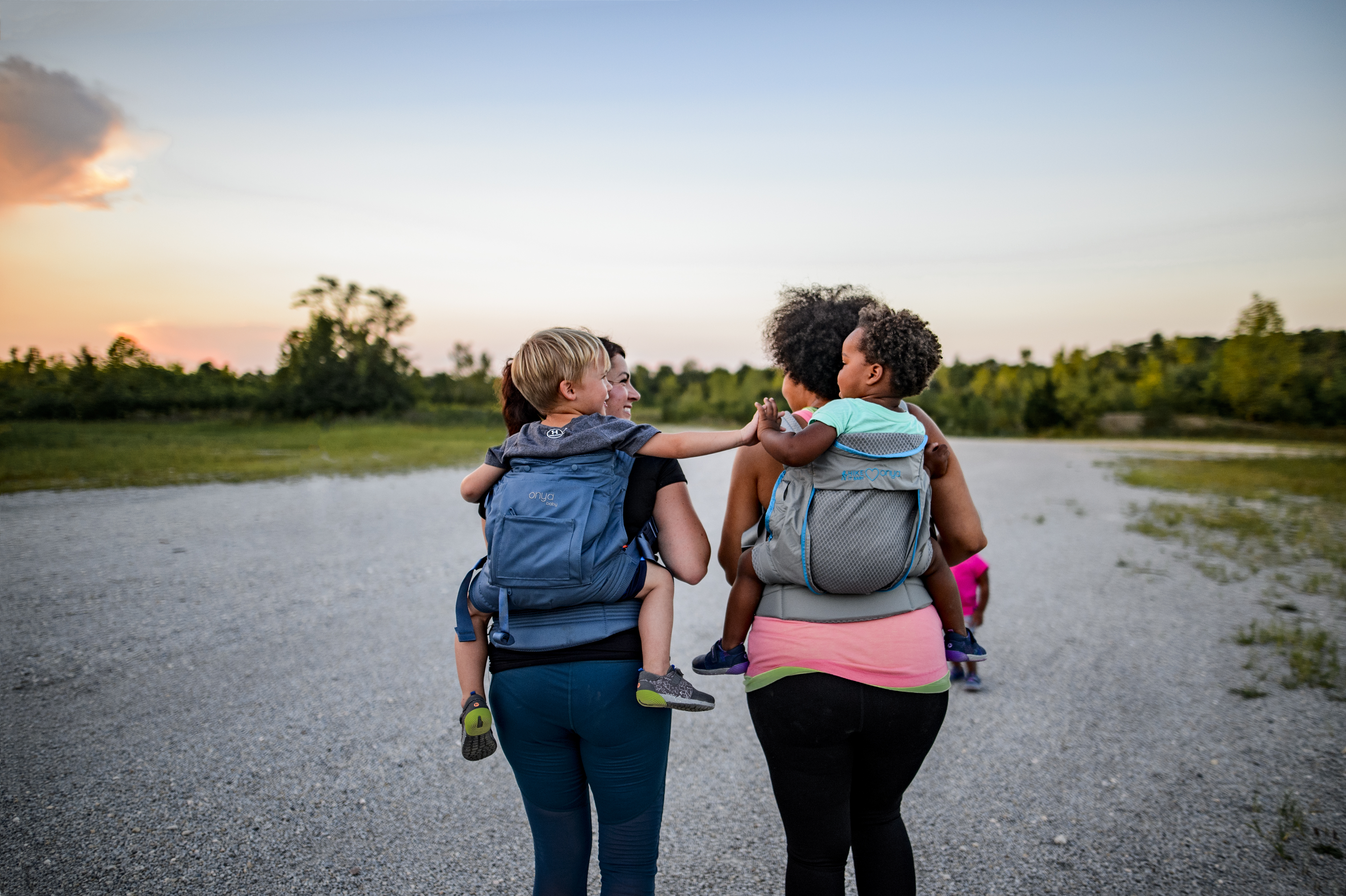 Photo by Laura Castro _ Burg Life Photography of two women with children in soft-structured back carriers outdoors